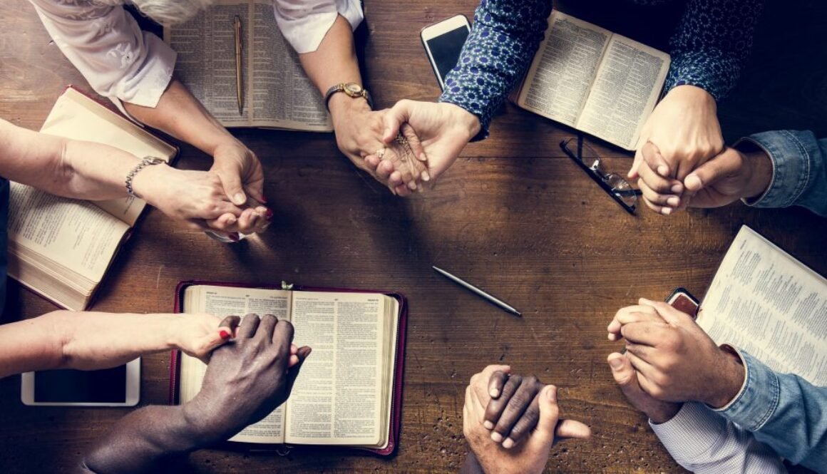 Group of people holding hands praying worship believe